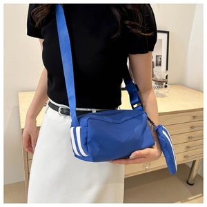 Blaue Oxford-Umhängetasche im Detail mit weißen Streifen und kleinem Münztäschchen