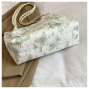 Detail of butterfly and constellation prints on cream tote bag with rope handles