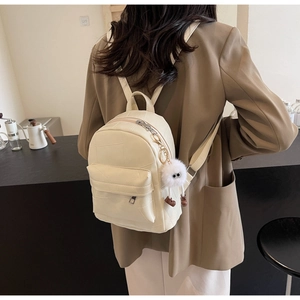 Rückansicht eines Models mit cremeweißem Mini-Rucksack aus PU-Leder mit Steppmuster