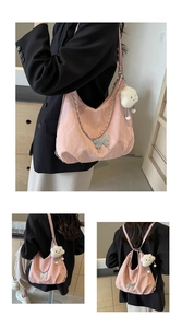 Close-up of pink nylon backpack featuring silver butterfly buckle and white cloud charm