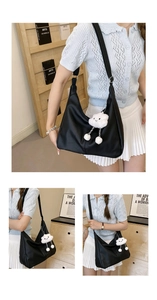 Close-up of black matte leather hobo bag with wide strap and white plush cloud charm