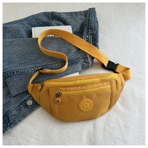 Détail du sac de poitrine jaune avec double zip et logo SPORT sur une veste en denim