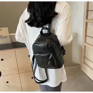 Nahaufnahme des schwarzen PU-Rucksacks mit Patchwork-Nähten an einem weiblichen Model