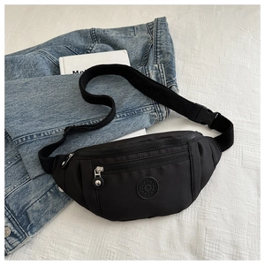 Détail du sac bandoulière en nylon noir imperméable avec logo SPORT sur fond décontracté