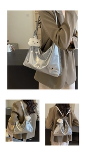 Macro shot of silver hobo bag with metallic butterfly accents and plush cloud charm