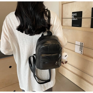 Detail des schwarzen PU-Lederrucksacks mit Patchwork-Design und Plüschlamm-Anhänger