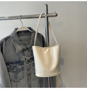 Close-up of a white bucket bag with pearl bow detail and Fashion & Bags text logo