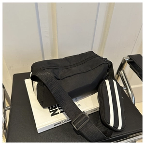 Detail der schwarzen Segeltuchtasche mit weißen Streifen und verstellbarem Gurt