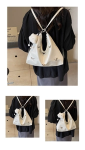 Detail of white glossy tote bag with metal butterflies and plush bear charm