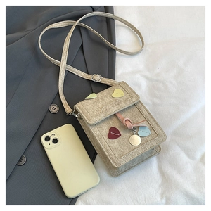 Vertical tweed crossbody phone bag with colorful heart patches and a round pendant