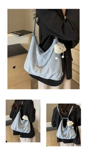 Macro detail of light blue pleated hobo bag featuring butterfly and cloud charms
