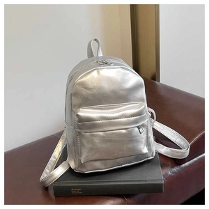 Detail of silver metallic PU mini backpack with front zipper pocket and sleek finish