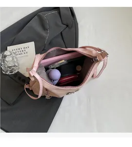 Interno della borsa in pelle rosa che mostra lo spazio per ombrello, telefono e caricatore
