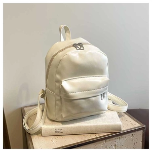 Detail of minimalist cream PU leather backpack featuring smooth texture and zipper pockets