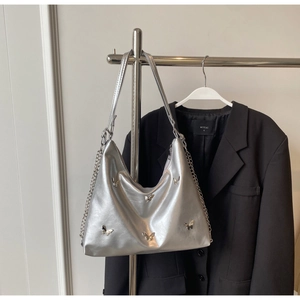 Detail of silver metallic shoulder bag with 3D butterfly charms on a metal hanger