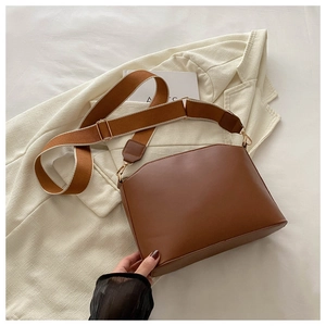 Close-up of brown PU leather hobo bag featuring a striped wide shoulder strap and gold hardware