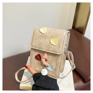 Detail of glitter textured small crossbody bag with colorful heart leather appliques