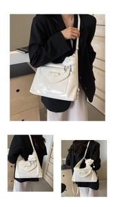 Detail of cream glossy PU leather tote bag featuring bow design and plush cloud charm