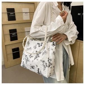 Detail of white butterfly print tote bag with woven shoulder strap for casual wear