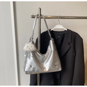 Detail of silver metallic butterfly tote bag with chain strap and plush charm accent