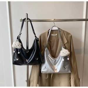 Detail of hobo bags in black and silver featuring metal butterfly and cloud charm
