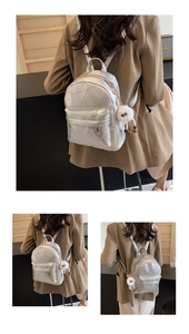 Nahaufnahme des silbernen Metall-Rucksacks mit Ziernähten und Plüsch-Anhänger
