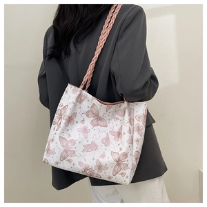 Detail of white tote bag with pink butterfly prints and woven shoulder strap