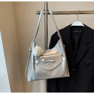 Close-up of silver metallic hobo bag with bow detail and soft cloud pendant