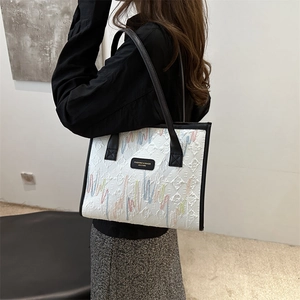 White minimalist tote bag with colorful wave embroidery and black leather handles