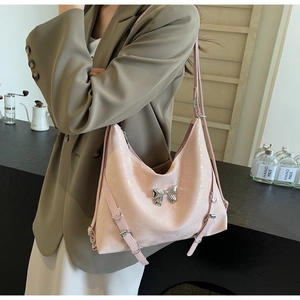 Dettaglio della borsa a tracolla rosa chiaro con fiocco metallico argento e fibbia