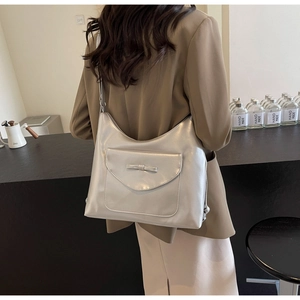 Detail of silver metallic hobo bag featuring a decorative bow and textured faux leather