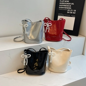 Glossy bucket bags in four colors featuring pearl bow charms and heart pendants