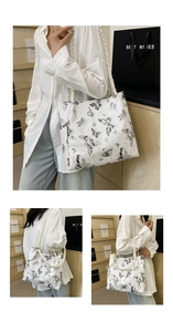 Detail of white tote bag with vintage butterfly print and braided shoulder strap