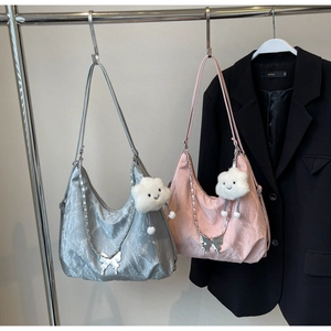 Detail of hobo shoulder bags with metallic butterfly chains and plush cloud charms