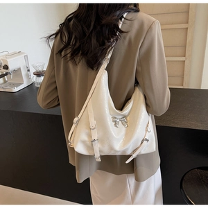 Dettaglio borsa shopper color crema lucido con fiocco in argento e cinturini decorativi