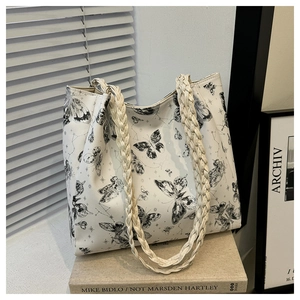Detail of butterfly print tote bag with woven rope handle and cross-grain texture