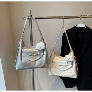 Detail of minimalist tote bags in silver and cream with cute plush cloud pendants