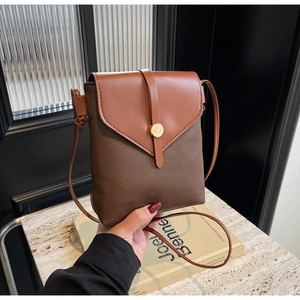 Detail of vintage crossbody phone bag with tan leather flap and gold metal buckle