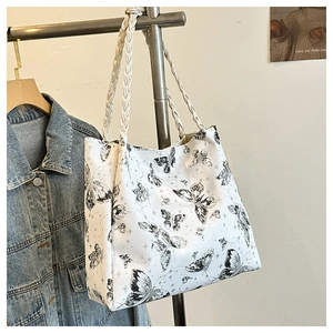 Detail of white tote bag with black butterfly print and sturdy woven shoulder straps