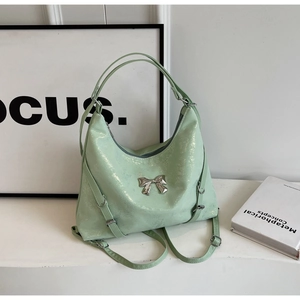 Dettaglio della borsa glitter verde menta con fiocco d'argento e trama scintillante