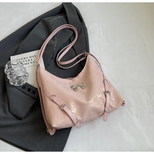 Dettaglio borsa tote in pelle verniciata rosa con fiocco argento e cinturini decor