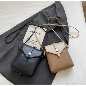 Close-up of mini leather crossbody bags in black and brown with litchi grain texture