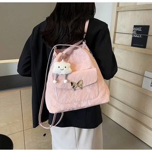 Detail of pink backpack featuring unique wrinkled texture and butterfly metal lock