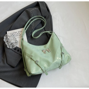 Dettaglio borsa tote verde menta metallizzato con fiocco argento e fibbie regolabili