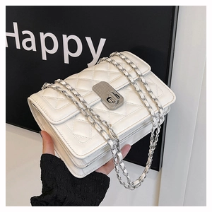 Detail view of white quilted crossbody bag with silver chain strap and metal clasp