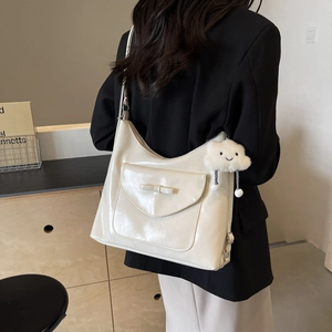 Minimalist cream white hobo tote bag with bow detail and cloud charm shown on model