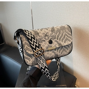 Detail of crossbody bag featuring retro wave pattern and wide geometric shoulder strap