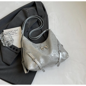 Dettaglio della borsa tote argento metallizzato con fiocco e fibbie in stile punk