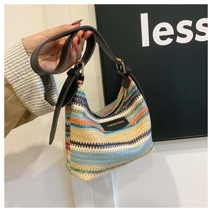 Detail of colorful woven shoulder bag featuring vibrant wave texture and leather logo patch