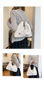 Detail view of white hobo bag with 3D butterfly patterns and silver chain accents